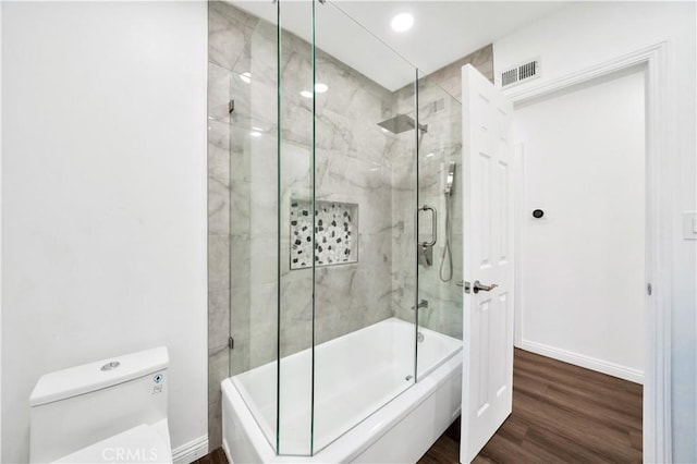 full bathroom with baseboards, enclosed tub / shower combo, toilet, visible vents, and wood finished floors