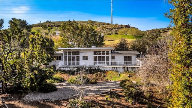 9970 Shadow Hills Dr, Sunland, CA 91040 - rear view of house featuring stucco siding, a sunroom, and a wooden deck