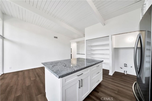 walk in closet featuring beam ceiling and dark wood finished floors