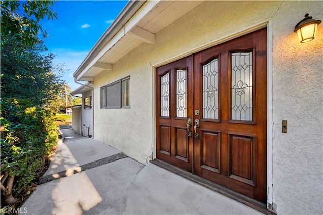 entrance to property featuring french doors and stucco siding