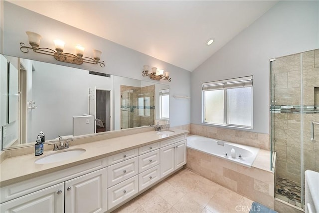 bathroom with vaulted ceiling, a stall shower, a garden tub, and a sink