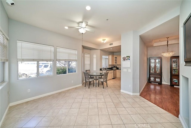 dining area with light tile patterned floors, ceiling fan with notable chandelier, and a wealth of natural light