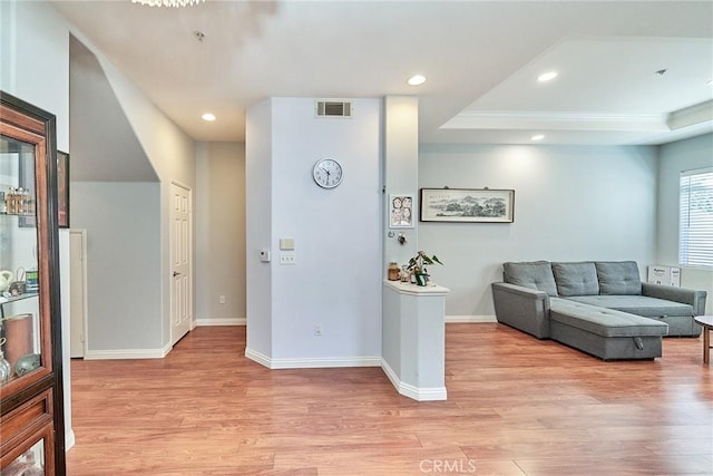 interior space with recessed lighting, visible vents, light wood-style flooring, and a raised ceiling