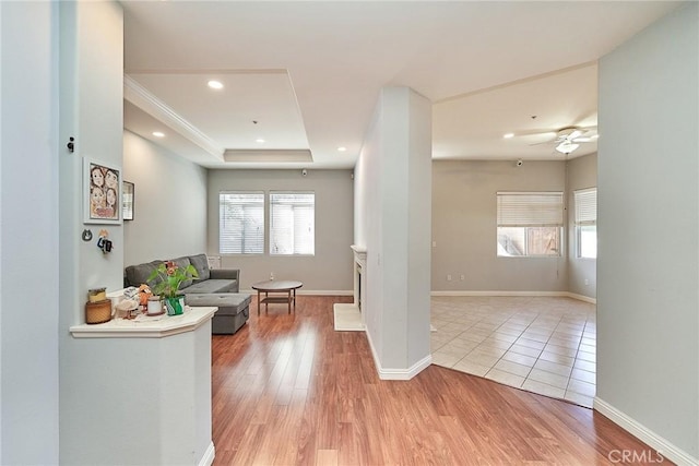 interior space featuring a wealth of natural light, a tray ceiling, and light wood-style floors