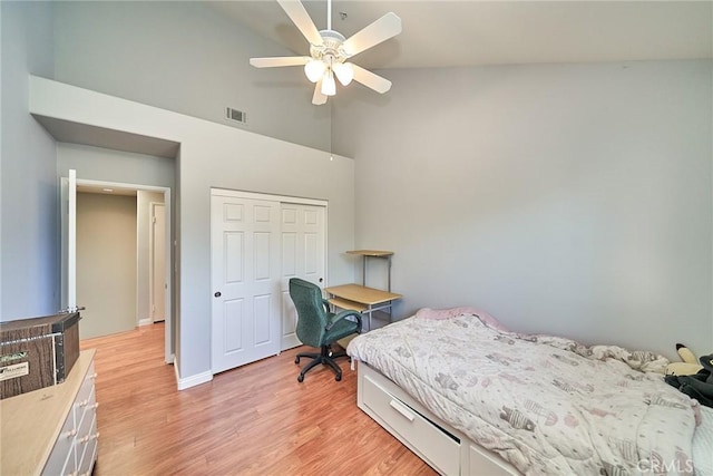 bedroom with visible vents, high vaulted ceiling, a closet, light wood-style floors, and baseboards