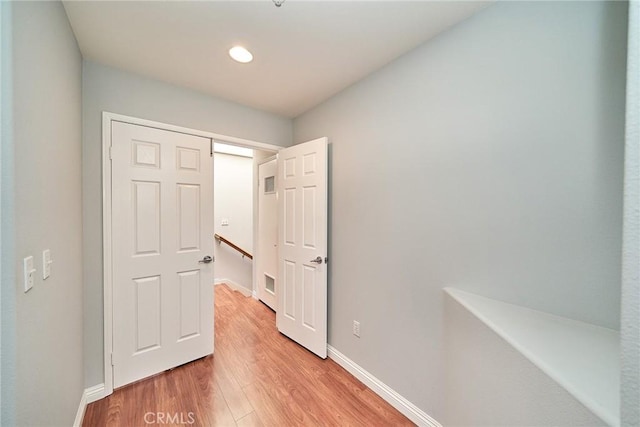 hall featuring recessed lighting, baseboards, and light wood-type flooring