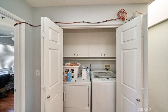 clothes washing area featuring cabinet space and washer and clothes dryer