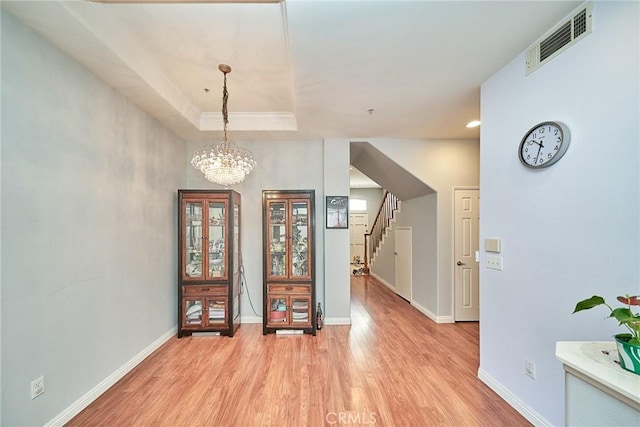 entrance foyer featuring light wood-type flooring, visible vents, baseboards, and stairway