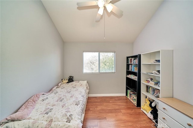 bedroom with a ceiling fan, vaulted ceiling, baseboards, and light wood-type flooring