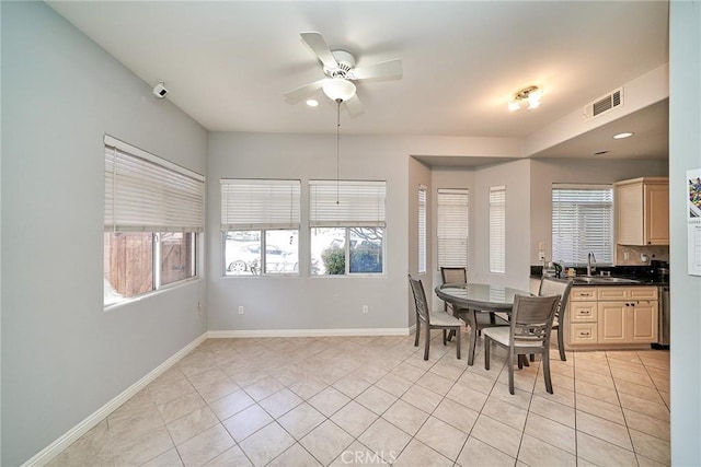 dining room featuring light tile patterned flooring, baseboards, visible vents, and a healthy amount of sunlight