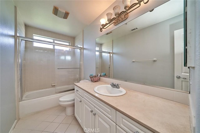 bathroom featuring vanity, visible vents, tile patterned floors, toilet, and combined bath / shower with glass door