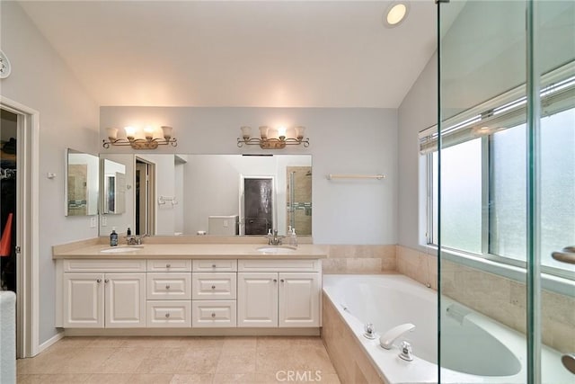 bathroom featuring double vanity, a sink, vaulted ceiling, a shower stall, and a garden tub