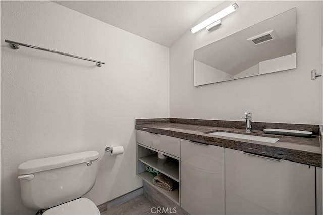 bathroom with visible vents, toilet, and vanity