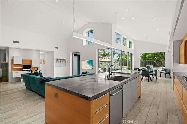 kitchen with visible vents, a large island with sink, a sink, dark countertops, and modern cabinets