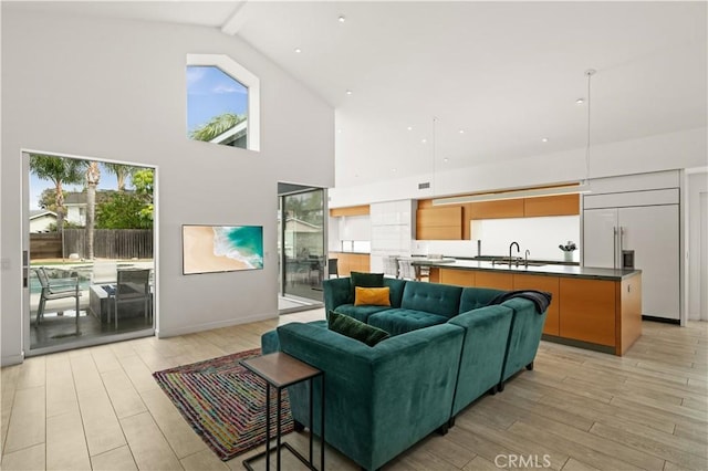 living area featuring beamed ceiling, light wood-style flooring, and high vaulted ceiling