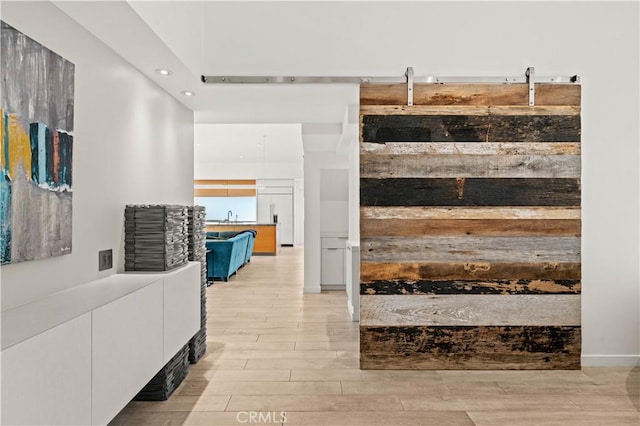 interior space with light wood finished floors, recessed lighting, and a sink