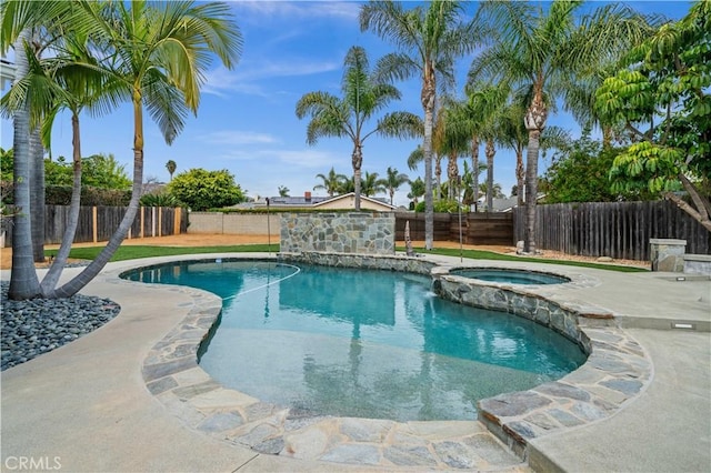 view of pool featuring a fenced backyard and a pool with connected hot tub