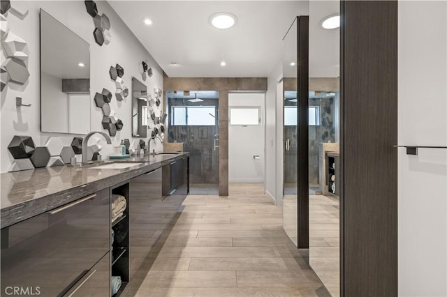 full bath with recessed lighting, wood finished floors, vanity, and a tile shower