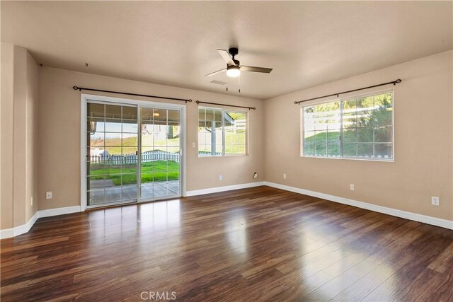 empty room with visible vents, wood finished floors, baseboards, and ceiling fan