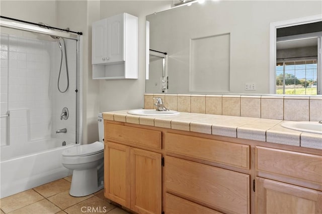 bathroom featuring toilet, a sink, tile patterned flooring, double vanity, and shower / bathtub combination