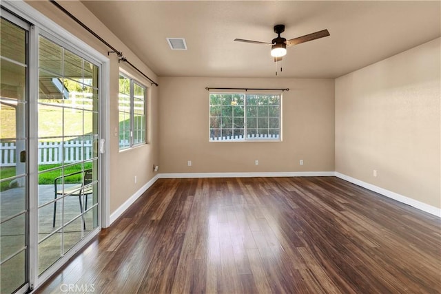 spare room featuring visible vents, a ceiling fan, baseboards, and wood finished floors