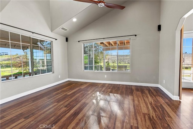 spare room with wood finished floors, arched walkways, visible vents, and baseboards