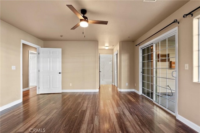 empty room with baseboards, wood finished floors, and a ceiling fan