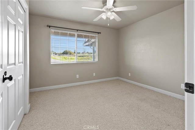 carpeted empty room with baseboards and a ceiling fan