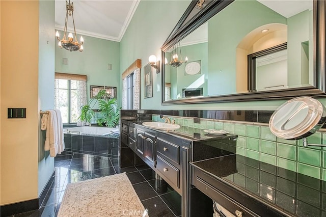 bathroom with vanity, a wainscoted wall, an inviting chandelier, ornamental molding, and a garden tub