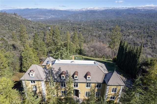 birds eye view of property with a mountain view and a view of trees