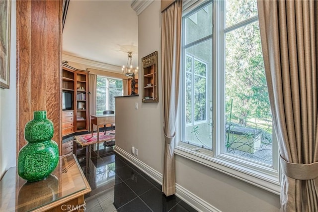 doorway featuring a chandelier, ornamental molding, baseboards, and dark tile patterned flooring