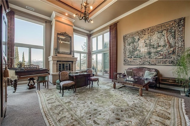 sitting room featuring crown molding, a healthy amount of sunlight, carpet, and a large fireplace