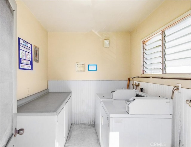 community laundry room with wainscoting and washer and dryer