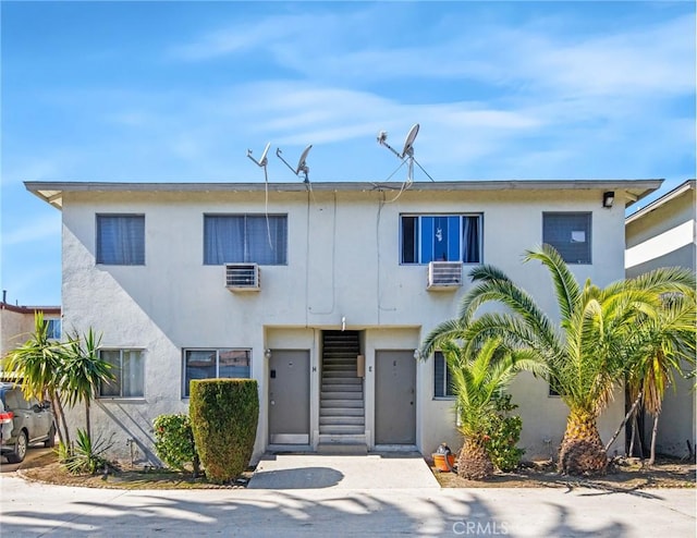 view of front of home featuring stucco siding and an AC wall unit