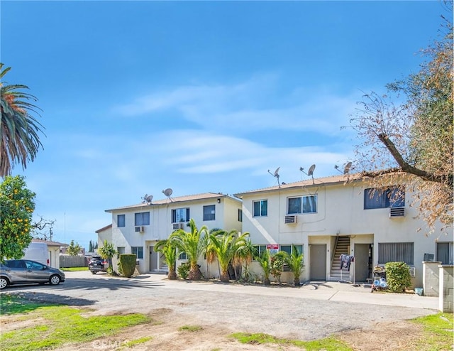 townhome / multi-family property featuring stucco siding and stairs