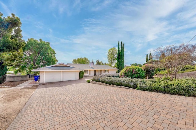 ranch-style home with decorative driveway and a garage