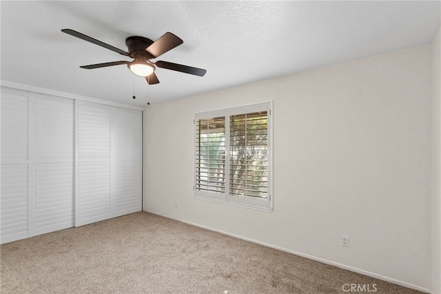 spare room featuring carpet flooring, a textured ceiling, and a ceiling fan