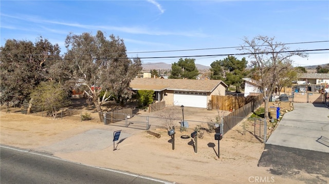 view of front of home featuring a fenced front yard, a garage, driveway, and a gate