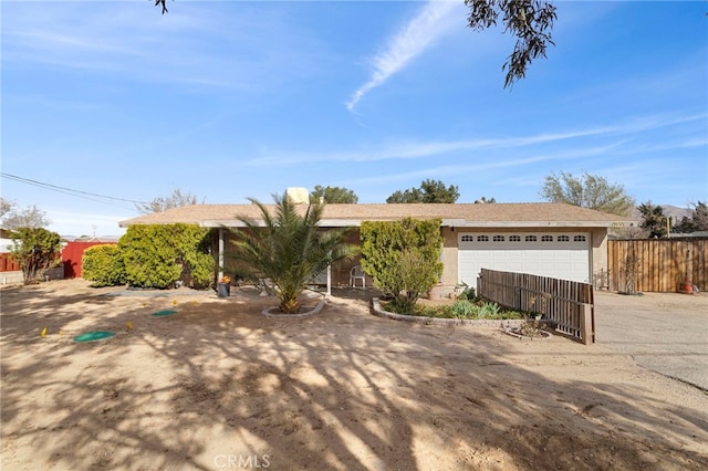 ranch-style home featuring stucco siding, a garage, and fence