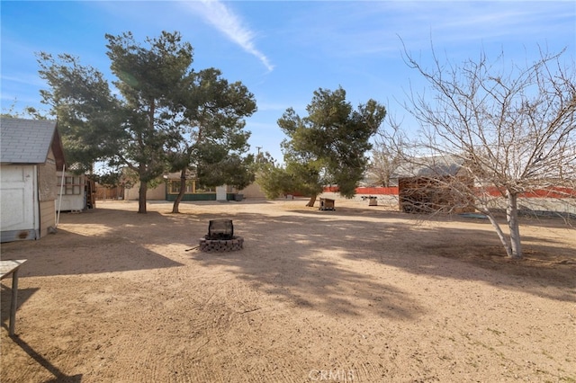 view of yard with an outdoor fire pit