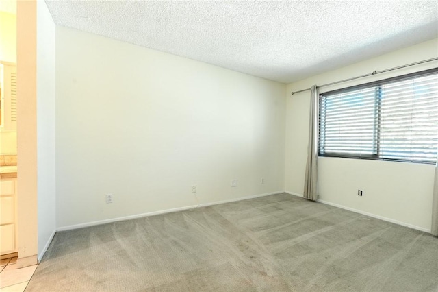 27666 Nugget Dr Unit 3, Canyon Country, CA 91387 - spare room featuring a textured ceiling, light colored carpet, and baseboards