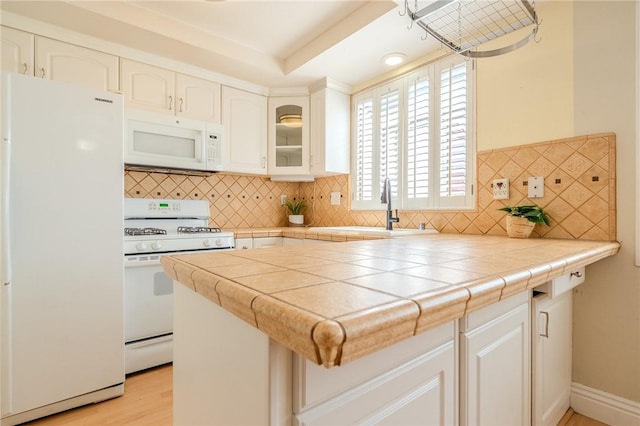 27666 Nugget Dr Unit 3, Canyon Country, CA 91387 - kitchen with white appliances, tasteful backsplash, glass insert cabinets, a sink, and white cabinetry