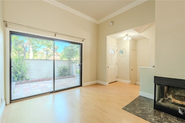27666 Nugget Dr Unit 3, Canyon Country, CA 91387 - unfurnished living room with healthy amount of natural light, ornamental molding, wood finished floors, baseboards, and a multi sided fireplace