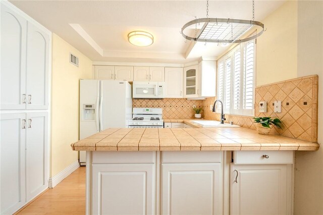 27666 Nugget Dr Unit 3, Canyon Country, CA 91387 - kitchen featuring white appliances, a sink, a peninsula, decorative backsplash, and a tray ceiling