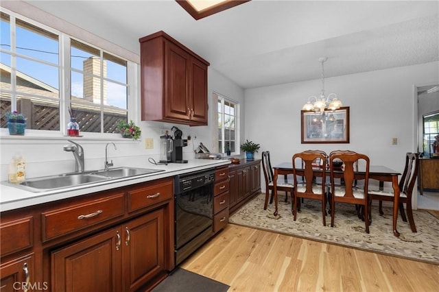 kitchen featuring decorative light fixtures, dishwasher, light wood-style flooring, an inviting chandelier, and a sink