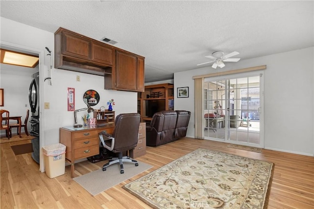 office area with visible vents, a textured ceiling, light wood-style floors, and a ceiling fan