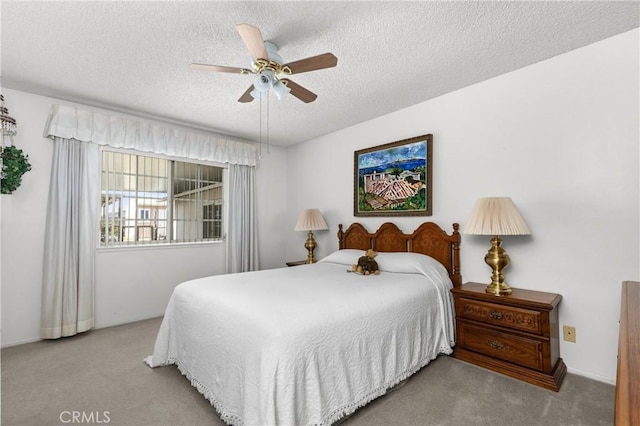 bedroom featuring a ceiling fan, carpet floors, and a textured ceiling