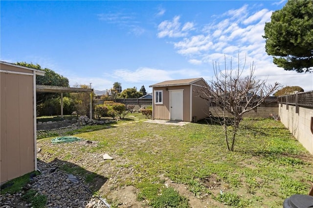 view of yard featuring an outbuilding, a storage unit, and a fenced backyard