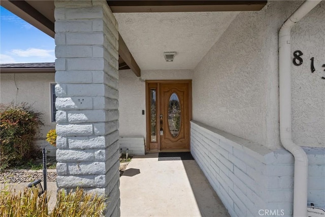 view of exterior entry with stucco siding