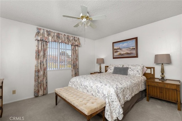 carpeted bedroom featuring a textured ceiling and a ceiling fan